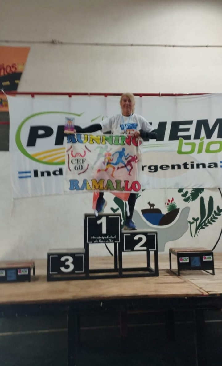 Mujer en el podio de una maratón sosteniendo una bandera de Prochem Bio